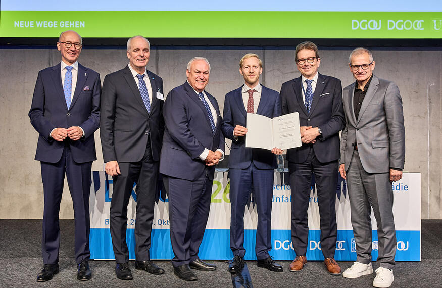 Preisverleihung des Preises zur Förderung der Rehabilitationsforschung der Deutschen Gesellschaft für Orthopädie und Unfallchirurgie (DGOU e. V.), gestiftet von der m&i-Klinikgruppe Enzensberg.   Von links:   Dr. med. Wolfgang Böker, Kongresspräsident des DKOU 2026 für den Berufsverband für Orthopädie und Unfallchirurgie (BVOU e. V.)  Dr. med. Jörn Dohle, Präsident der Deutschen Gesellschaft für Orthopädie und Orthopädische Chirurgie (DGOOC e. V.), stv. Präsident der Deutschen Gesellschaft für Orthopädie und Unfallchirurgie (DGOU e. V.)  Prof. Dr. med. Bernd Kladny, Generalsekretär der Deutschen Gesellschaft für Orthopädie und Unfallchirurgie (DGOU e. V.) und der Deutschen Gesellschaft für Orthopädie und Orthopädische Chirurgie (DGOOC e. V.), Vertreter des Stifters und Chefarzt der m&i-Fachklinik Herzogenaurach   Priv.-Doz. Dr. med. Henryk Paul Hans Haffer, Preisträger, Centrum für Muskuloskeletale Chirurgie, Charité – Universitätsmedizin Berlin  Prof. Dr. med. Frank Hildebrand, Präsident der Deutschen Gesellschaft für Orthopädie und Unfallchirurgie (DGOU e. V.) und der Deutschen Gesellschaft für Unfallchirurgie (DGU e. V.)  Prof. Dr. med. Sascha Flohé, Generalsekretär der Deutschen Gesellschaft für Unfallchirurgie (DGU e. V.) und stv. Generalsekretär der Deutschen Gesellschaft für Orthopädie und Unfallchirurgie (DGOU e. V.) 