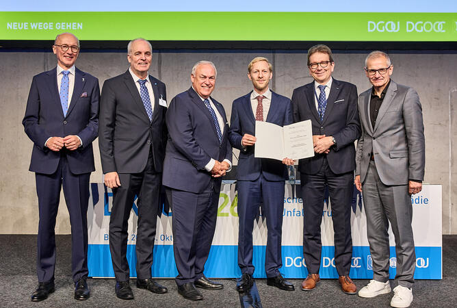 Preisverleihung des Preises zur Förderung der Rehabilitationsforschung der Deutschen Gesellschaft für Orthopädie und Unfallchirurgie (DGOU e. V.), gestiftet von der m&i-Klinikgruppe Enzensberg.   Von links:   Dr. med. Wolfgang Böker, Kongresspräsident des DKOU 2026 für den Berufsverband für Orthopädie und Unfallchirurgie (BVOU e. V.)  Dr. med. Jörn Dohle, Präsident der Deutschen Gesellschaft für Orthopädie und Orthopädische Chirurgie (DGOOC e. V.), stv. Präsident der Deutschen Gesellschaft für Orthopädie und Unfallchirurgie (DGOU e. V.)  Prof. Dr. med. Bernd Kladny, Generalsekretär der Deutschen Gesellschaft für Orthopädie und Unfallchirurgie (DGOU e. V.) und der Deutschen Gesellschaft für Orthopädie und Orthopädische Chirurgie (DGOOC e. V.), Vertreter des Stifters und Chefarzt der m&i-Fachklinik Herzogenaurach   Priv.-Doz. Dr. med. Henryk Paul Hans Haffer, Preisträger, Centrum für Muskuloskeletale Chirurgie, Charité – Universitätsmedizin Berlin  Prof. Dr. med. Frank Hildebrand, Präsident der Deutschen Gesellschaft für Orthopädie und Unfallchirurgie (DGOU e. V.) und der Deutschen Gesellschaft für Unfallchirurgie (DGU e. V.)  Prof. Dr. med. Sascha Flohé, Generalsekretär der Deutschen Gesellschaft für Unfallchirurgie (DGU e. V.) und stv. Generalsekretär der Deutschen Gesellschaft für Orthopädie und Unfallchirurgie (DGOU e. V.) 